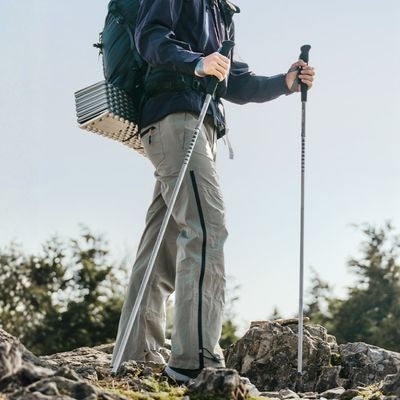 Homme debout batons de randonnée pliables sommet