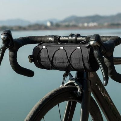 Homme devant baie mer sacoche pour guidon velo fixée