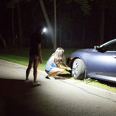 Homme éclaire roue voiture avec lampe frontale rechargeable usb
