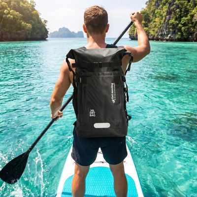 Homme fait paddle avec sac à dos étanche dans dos