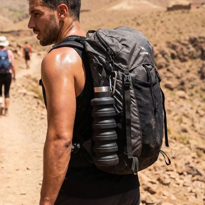Homme fait trek avec gourde pour sport attachée sac