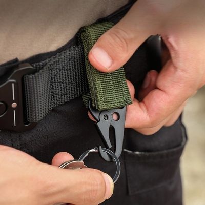 Homme insère clés dans mousqueton ceinture randonnée