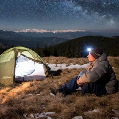 Homme lampe frontale puissante professionnel regarde nuit étoilée