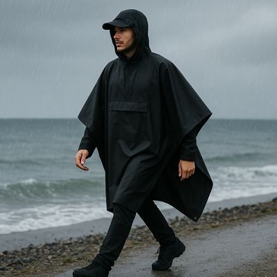 Homme marche bord de mer avec poncho pluie
