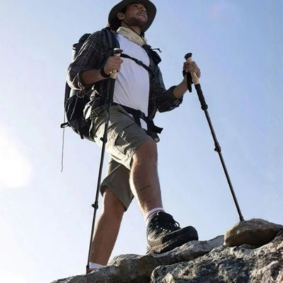 Homme marche sommet roche batons de marche téléscopique