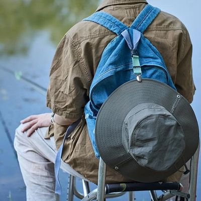 Homme pêche avec chapeau fixe mousqueton sac