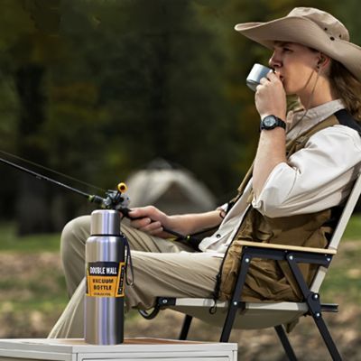 Homme assis pêche avec mug isotherme pratique posée côté