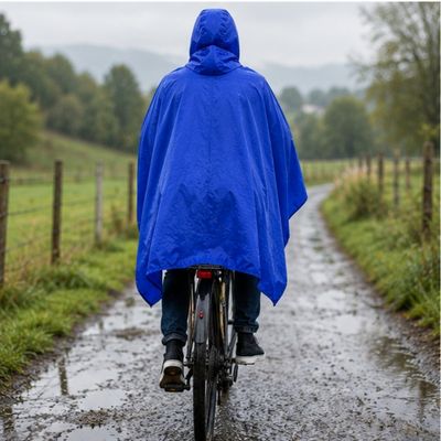 Homme poncho pluie velo roule petite route campagne