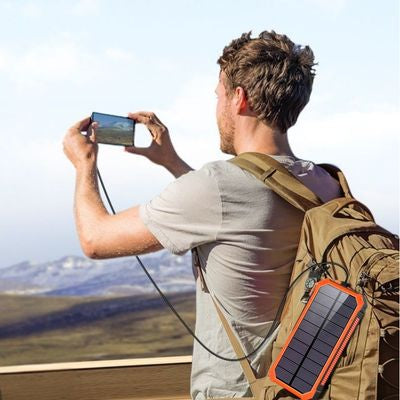 Homme prend photo téléphone branché batterie nomade solaire