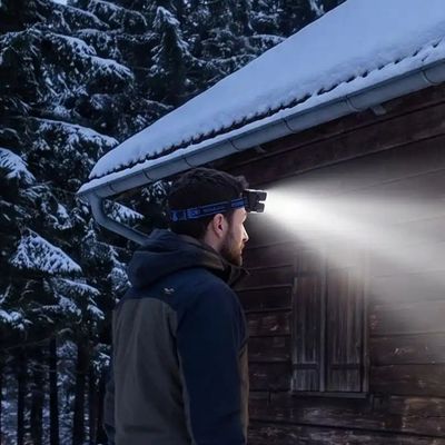 Homme près refuge après randonnée lampe frontale sur tête