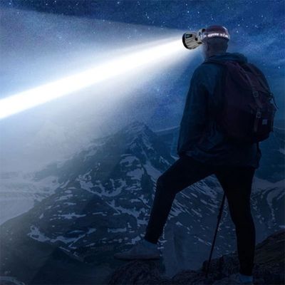 Homme puissante lampe frontale admire pics montagne