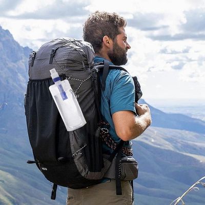 Homme randonne avec gourde filtrante fixée sac à dos