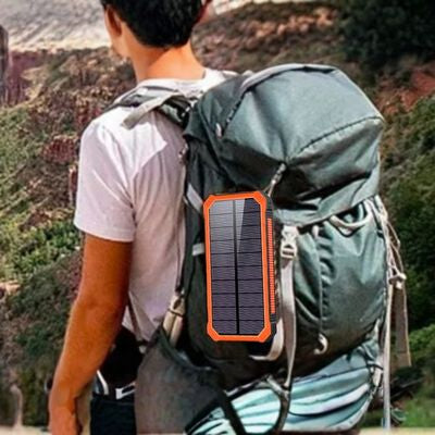 Homme randonne batterie nomade solaire fixée sac à dos