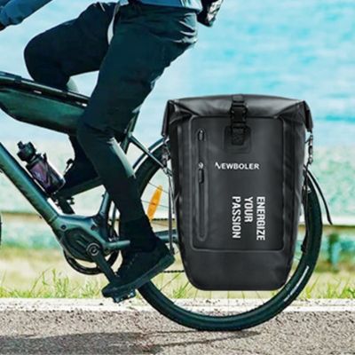 Homme randonne bord mer une des sacoches vélo attachée