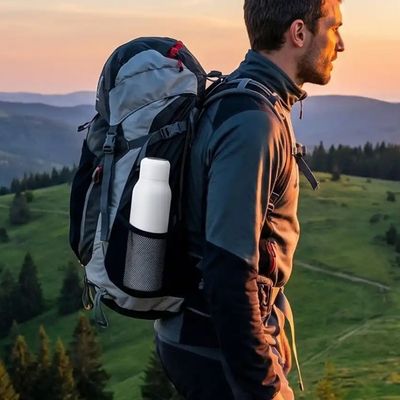 Homme randonne bouteille isotherme purificatrice dans poche latérale sac