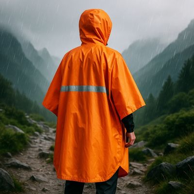 Homme randonne montagne avec poncho de pluie