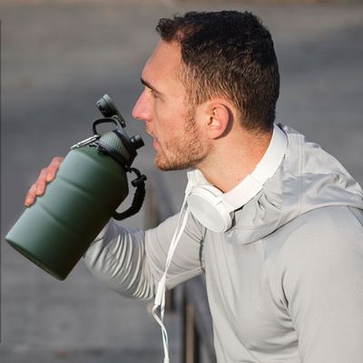 Homme randonnée boit dans gourde isotherme
