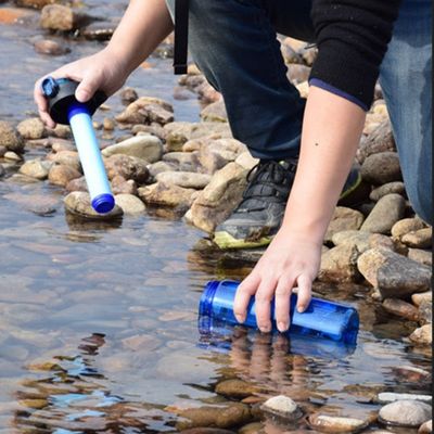 Homme remplie sa gourde filtre eau bord ruisseau