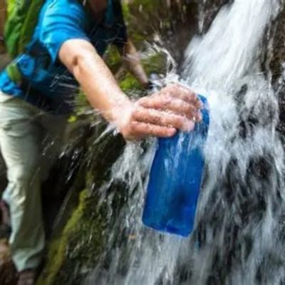 Homme remplit gourde filtrante eau non potable