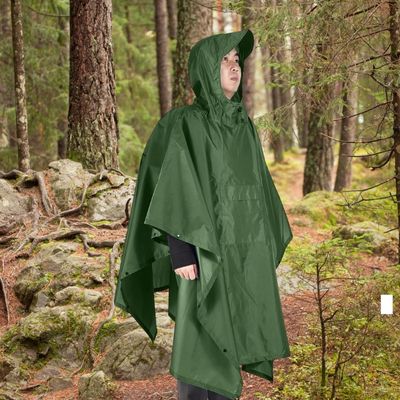 Homme sac a dos avec poncho de pluie sous bois