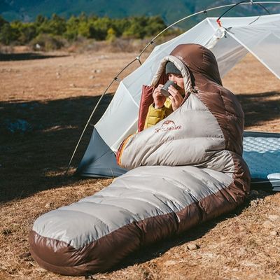 Homme sac de couchage grand froid boit gobelet