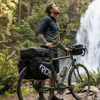 Homme sacoche porte bagage vélo attachée admire cascade