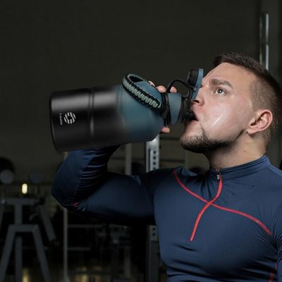 Homme salle musculation boit dans gourde isotherme