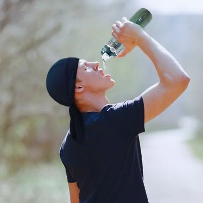 Homme se désaltère gourde filtrante randonnée
