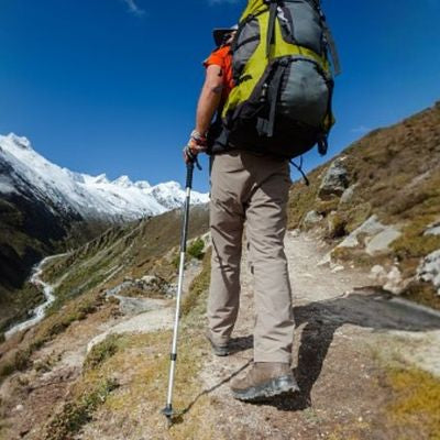 Homme sentier escarpé batons de randonnée