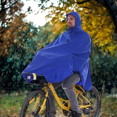 Homme serein chemin forêt poncho pluie vélo
