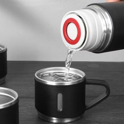 Homme sert eau mug thermos dans tasses