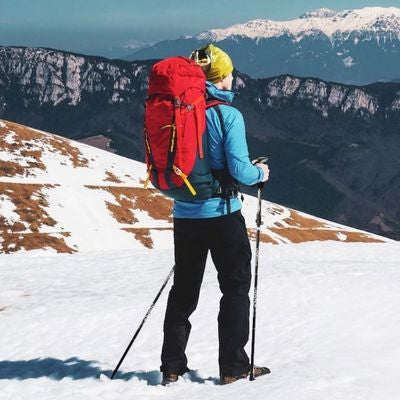 Homme sommet enneigé vue dégagée baton pour le trail