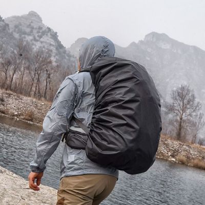 Homme suit cours rivière housse de pluie sac à dos