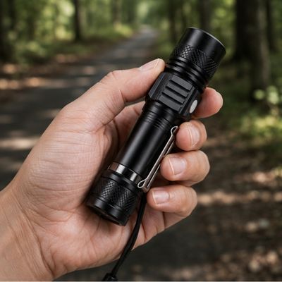 Homme tient dans main lampe de poche rechargeable