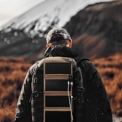 Homme trekking panneau solaire souple fixé sac