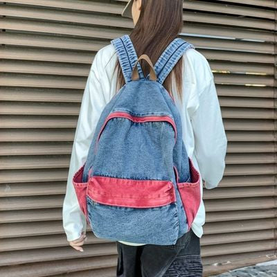 Jeune fille sac a dos primaire devant palissade
