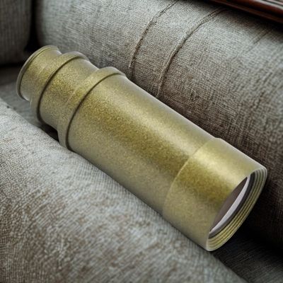 Jumelle monoculaire allongée entre des coussins