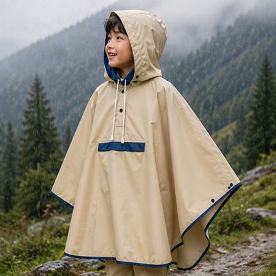 Petit garçon tout sourire couvert poncho pluie enfant