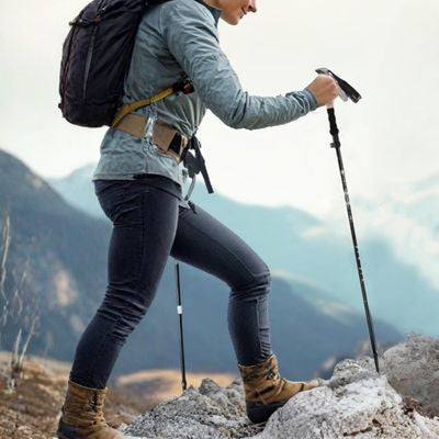 Randonneuse montagne batons randonnée rocher