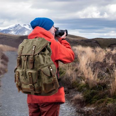 Sac à dos cuir homme prend photo crêtes montagne