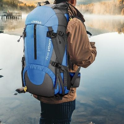 Sac à dos femme debout sur pierre bord lac