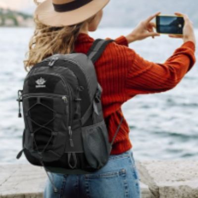 Femme prend photo mer avec sac à dos petit