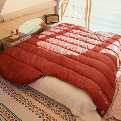 Sac de couchage 0 degré étalé sur lit caravane