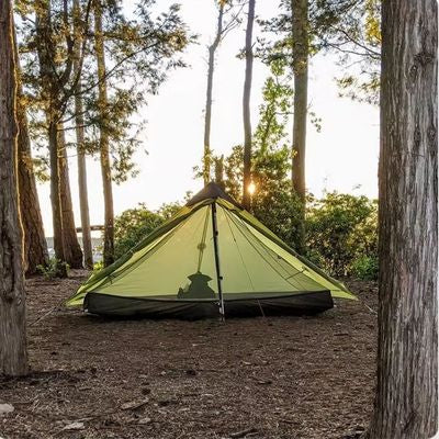 Tente 1 place plantée derrière buisson