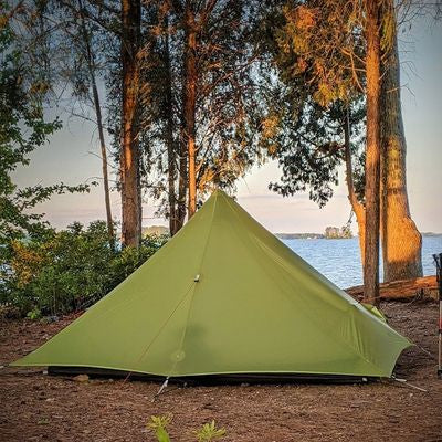 Vue dos tente 1 place plantée bord lac